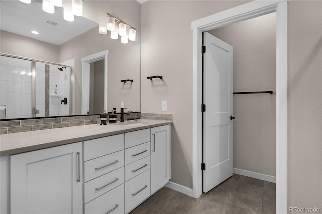 bathroom featuring tile patterned floors, walk in shower, vanity, and backsplash