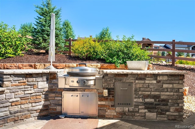 view of patio / terrace featuring an outdoor kitchen, fence, and a grill
