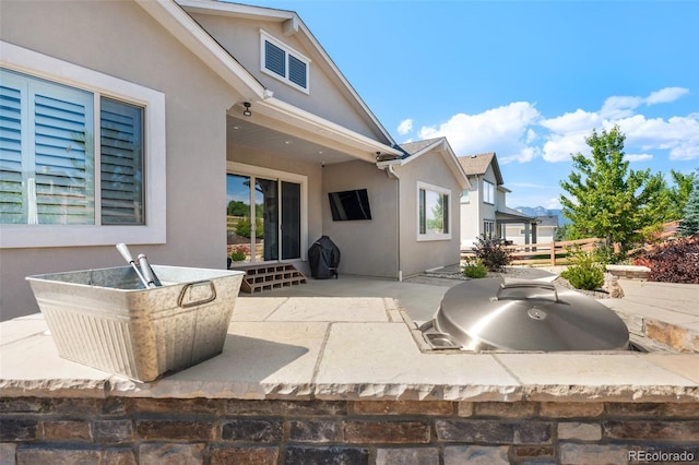 rear view of property featuring stucco siding and a patio area