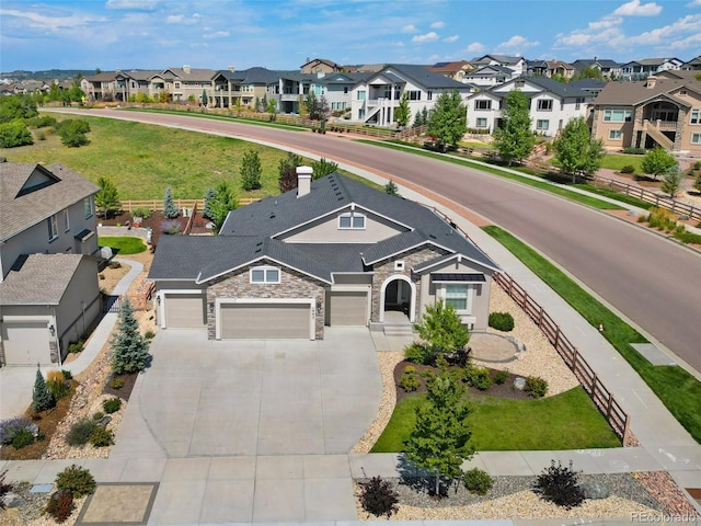view of front of home featuring a residential view, concrete driveway, a garage, and stone siding