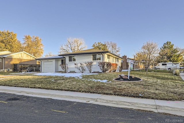 ranch-style house featuring a front yard and a garage