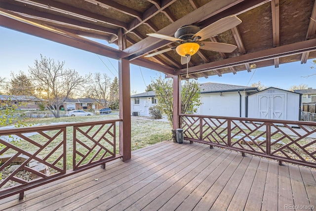 deck with ceiling fan, a storage shed, and a yard