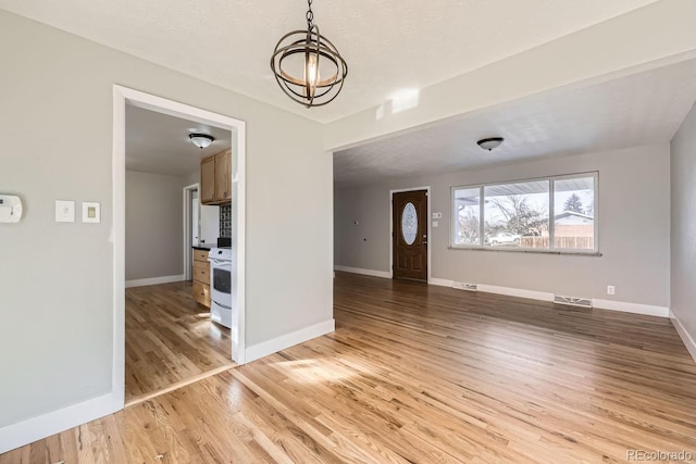 interior space with a notable chandelier and hardwood / wood-style flooring