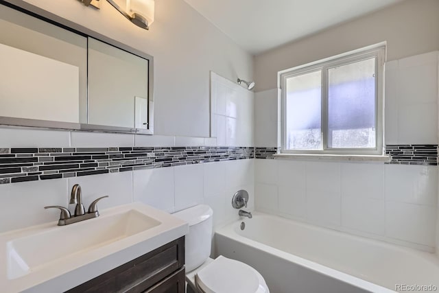 full bathroom with shower / washtub combination, vanity, tile walls, and toilet