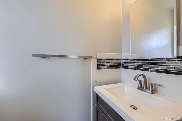 bathroom featuring vanity and tasteful backsplash