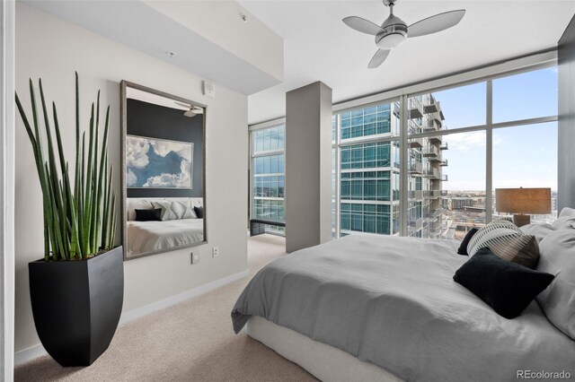 bedroom with expansive windows, multiple windows, carpet flooring, and baseboards