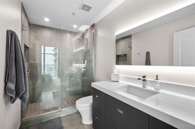 full bath with a stall shower, visible vents, toilet, vanity, and recessed lighting