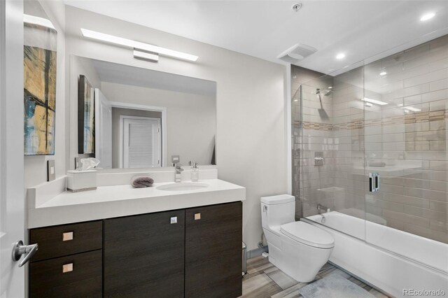 full bath with shower / bath combination with glass door, recessed lighting, visible vents, toilet, and vanity