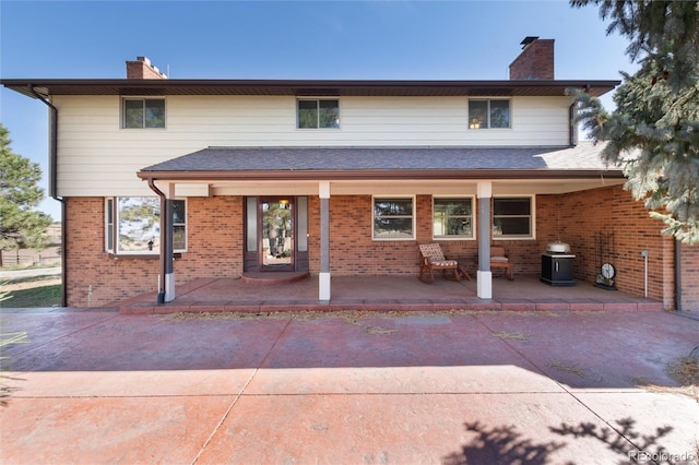 back of property featuring covered porch