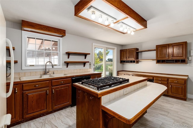 kitchen featuring sink, stainless steel gas cooktop, a center island, and black dishwasher