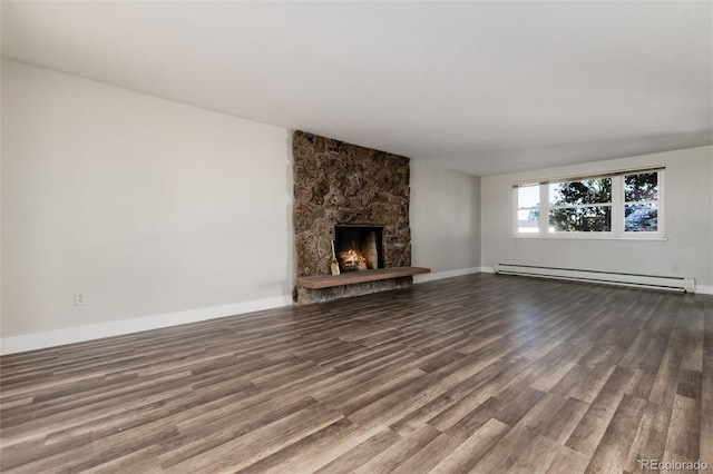 unfurnished living room featuring a stone fireplace, a baseboard heating unit, and hardwood / wood-style floors