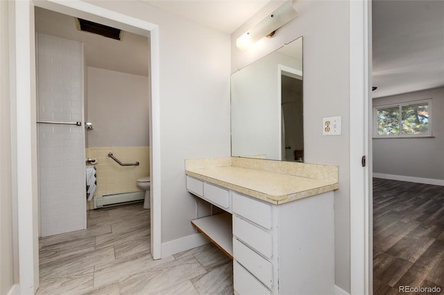 bathroom with vanity, toilet, baseboard heating, and hardwood / wood-style floors