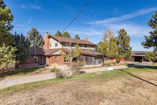 front facade with a sunroom and a front yard