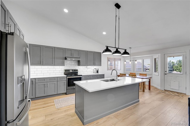525 Badger Creek Dr, Brighton, CO 80601 - kitchen with stainless steel appliances, under cabinet range hood, light countertops, gray cabinets, and tasteful backsplash