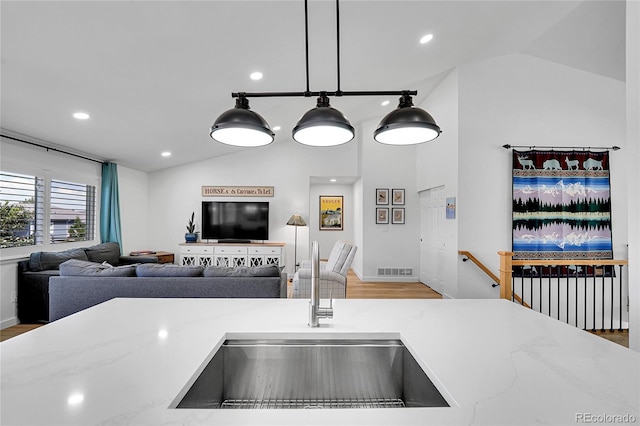 525 Badger Creek Dr, Brighton, CO 80601 - kitchen featuring lofted ceiling, recessed lighting, open floor plan, wood finished floors, and decorative light fixtures