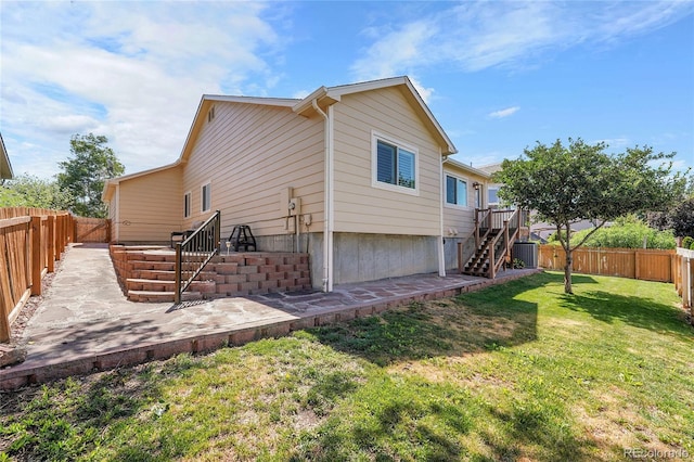525 Badger Creek Dr, Brighton, CO 80601 - rear view of property featuring stairs, a fenced backyard, and a patio area