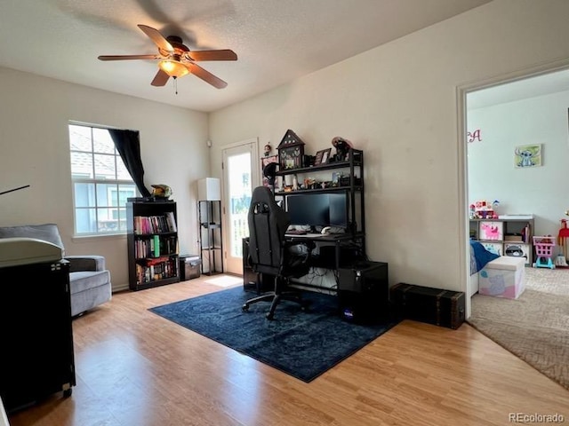 home office featuring light wood-type flooring and ceiling fan