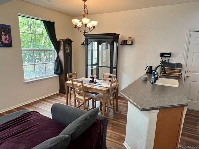 dining area with plenty of natural light, sink, hardwood / wood-style flooring, and a chandelier