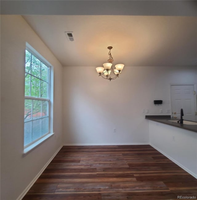 8802 E 24th Pl Unit 101, Denver, CO 80238 - unfurnished dining area featuring a chandelier, dark wood-style flooring, baseboards, and a sink