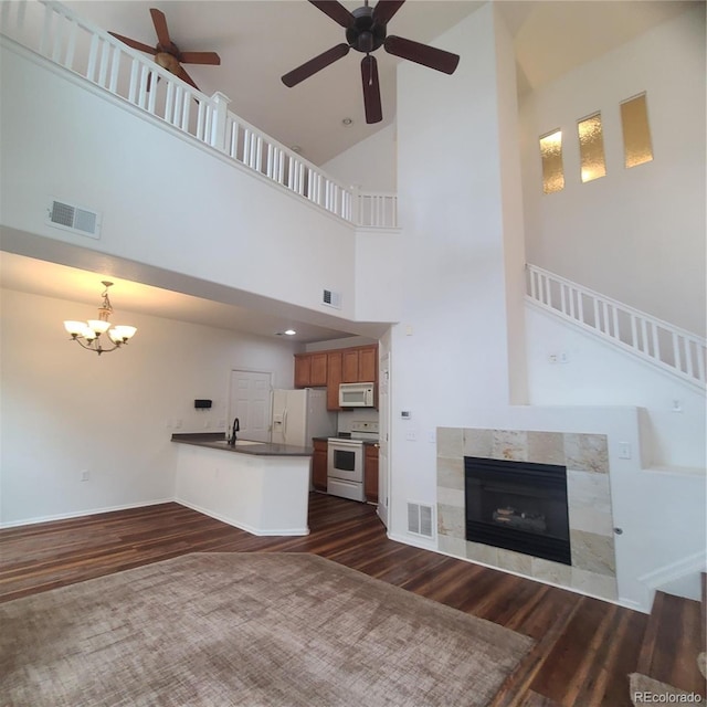 8802 E 24th Pl Unit 101, Denver, CO 80238 - unfurnished living room with dark wood-type flooring, ceiling fan, a chandelier, and high vaulted ceiling
