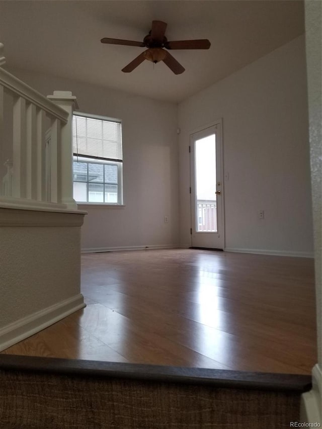 8802 E 24th Pl Unit 101, Denver, CO 80238 - unfurnished room featuring ceiling fan, wood finished floors, baseboards, and stairs