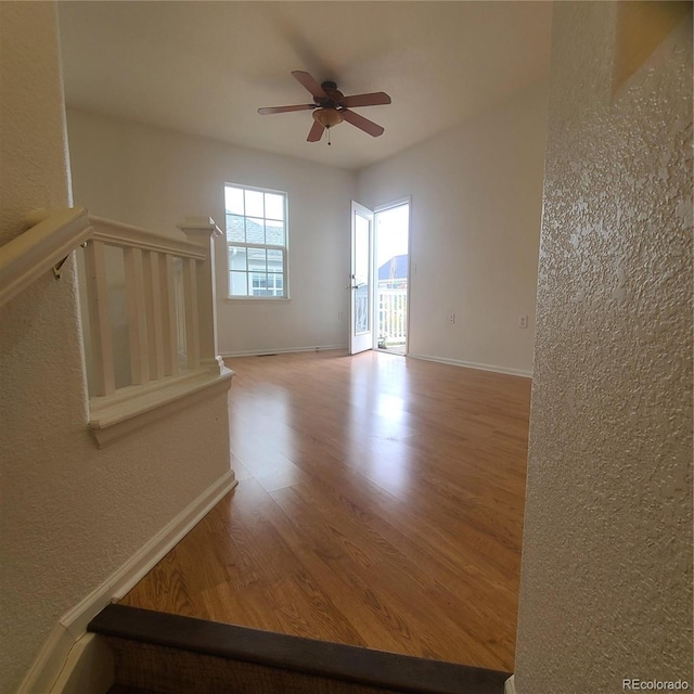 8802 E 24th Pl Unit 101, Denver, CO 80238 - unfurnished room featuring wood finished floors, a ceiling fan, a textured wall, and baseboards