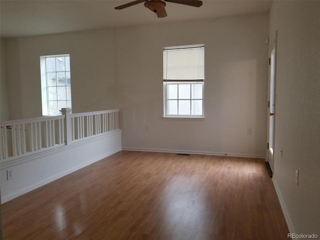 8802 E 24th Pl Unit 101, Denver, CO 80238 - empty room with ceiling fan, plenty of natural light, wood finished floors, and baseboards