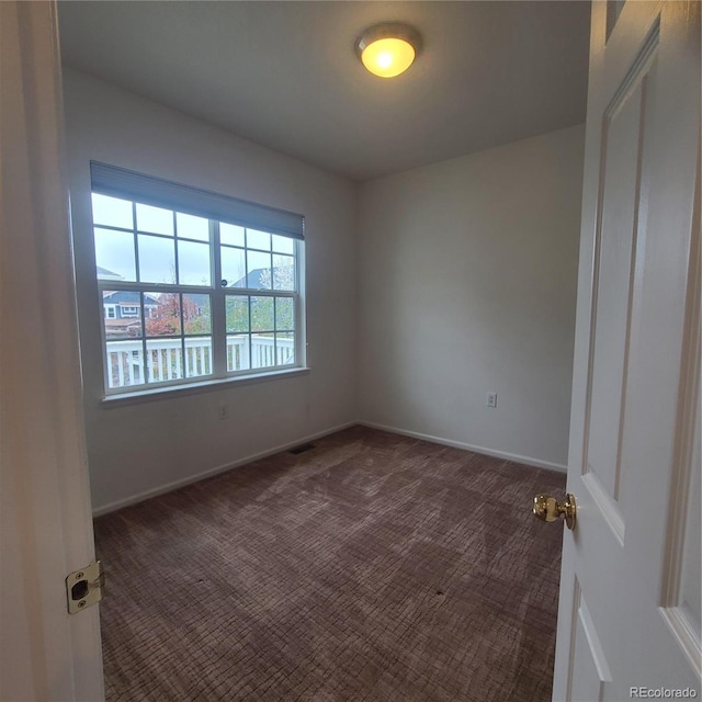 8802 E 24th Pl Unit 101, Denver, CO 80238 - empty room featuring dark colored carpet and baseboards