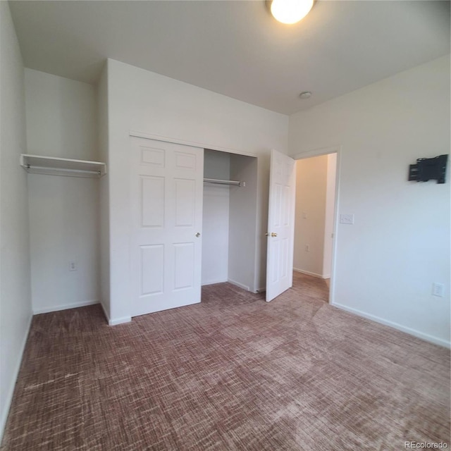 8802 E 24th Pl Unit 101, Denver, CO 80238 - unfurnished bedroom with a closet, carpet floors, and baseboards