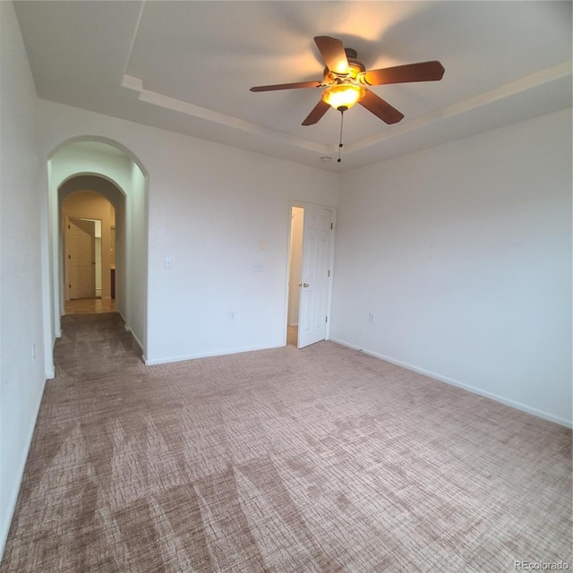 8802 E 24th Pl Unit 101, Denver, CO 80238 - carpeted spare room featuring a raised ceiling, ceiling fan, arched walkways, and baseboards