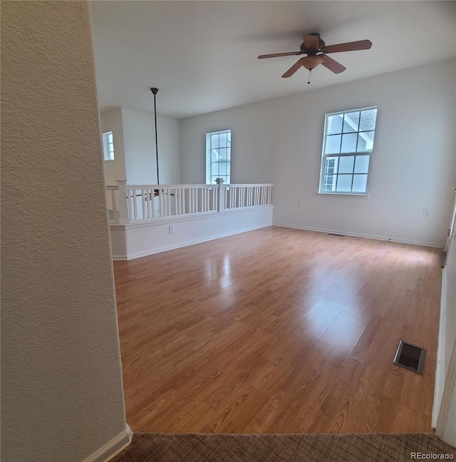 8802 E 24th Pl Unit 101, Denver, CO 80238 - spare room featuring a ceiling fan, wood finished floors, and baseboards