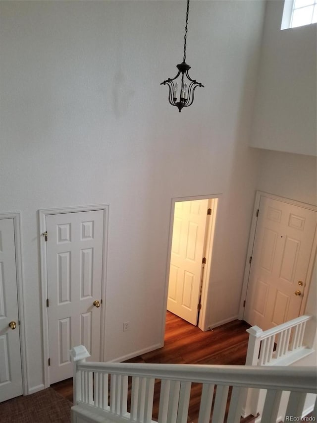 8802 E 24th Pl Unit 101, Denver, CO 80238 - stairway featuring a high ceiling, wood finished floors, and a chandelier