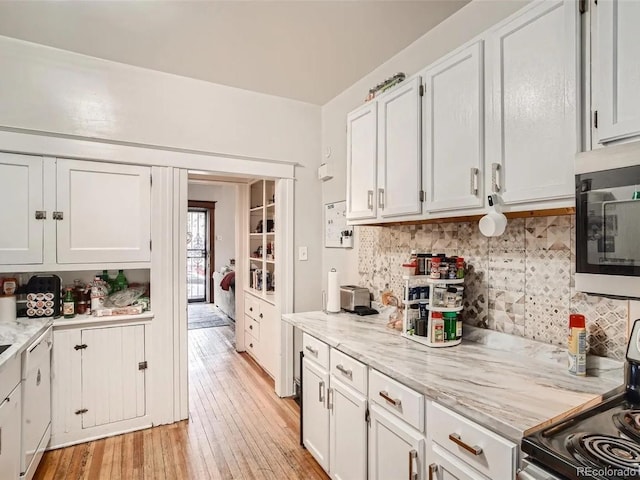 kitchen with white cabinets, stainless steel appliances, light hardwood / wood-style flooring, and light stone countertops