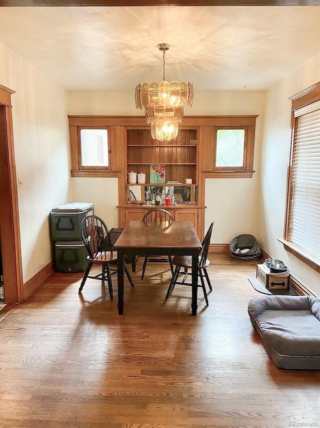 dining room featuring hardwood / wood-style floors and an inviting chandelier