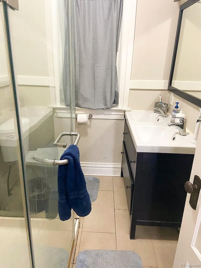 bathroom with tile patterned flooring, vanity, and walk in shower