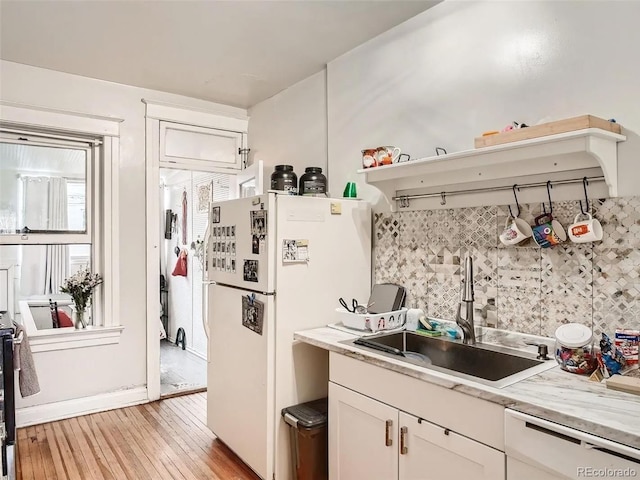 kitchen featuring tasteful backsplash, white appliances, sink, white cabinets, and light hardwood / wood-style floors