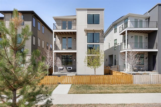 21418 E 61st Dr, Aurora, CO 80019 - back of house with a balcony and a fenced front yard