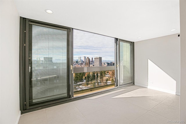 unfurnished room featuring light tile patterned floors and a wall of windows