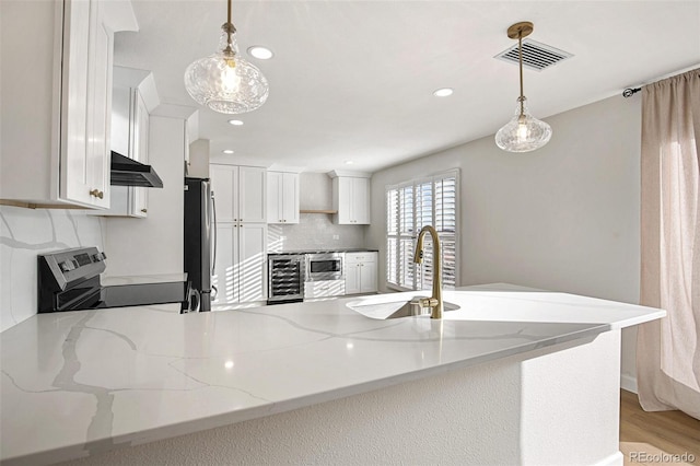 kitchen with white cabinetry, beverage cooler, stainless steel appliances, and decorative light fixtures