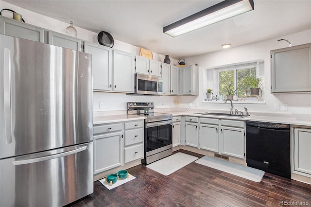 kitchen featuring appliances with stainless steel finishes, dark wood-type flooring, and sink