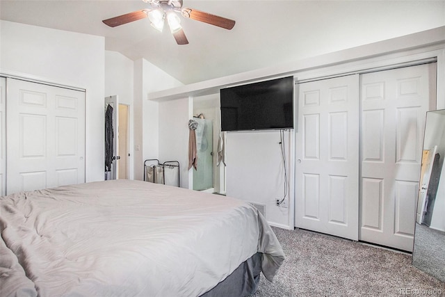 carpeted bedroom featuring ceiling fan, two closets, and vaulted ceiling