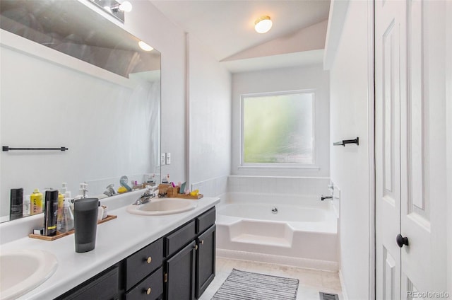 bathroom with tile patterned flooring, a tub to relax in, and vanity