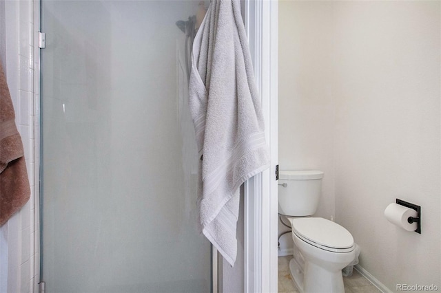 bathroom featuring a shower with shower door, toilet, and tile patterned flooring