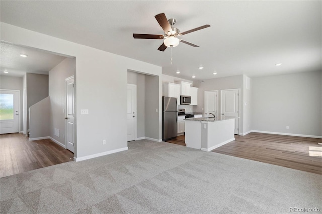7307 Dolores Ave, Frederick, CO 80530 - unfurnished living room featuring carpet, ceiling fan, recessed lighting, and wood finished floors