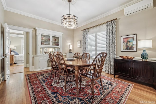 836 E 17th Ave Unit 1A, Denver, CO 80218 - dining room featuring a wall unit AC, light wood-type flooring, crown molding, and a chandelier