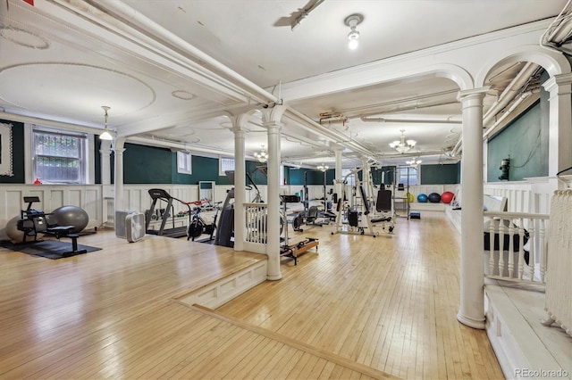 836 E 17th Ave Unit 1A, Denver, CO 80218 - exercise room featuring decorative columns, hardwood / wood-style floors, and a wainscoted wall