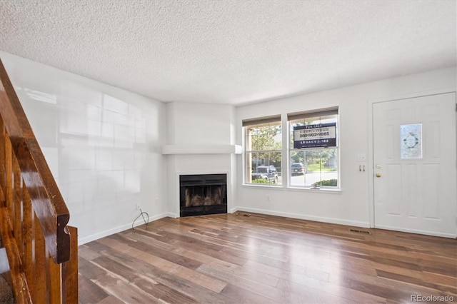 3094 W 107th Pl Unit B, Westminster, CO 80031 - unfurnished living room featuring a textured ceiling, a fireplace, and wood finished floors