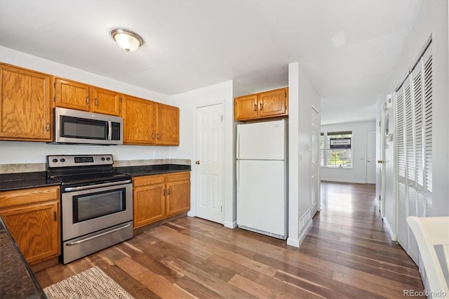 3094 W 107th Pl Unit B, Westminster, CO 80031 - kitchen with appliances with stainless steel finishes, dark wood-style floors, brown cabinetry, and dark countertops