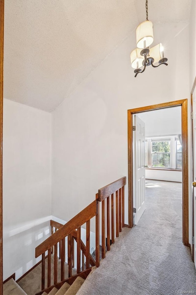 3094 W 107th Pl Unit B, Westminster, CO 80031 - hallway featuring carpet floors, a chandelier, lofted ceiling, an upstairs landing, and a textured ceiling