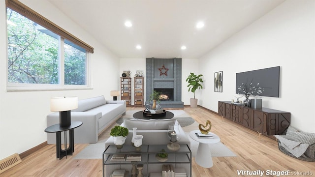 living room with light wood-type flooring and a fireplace